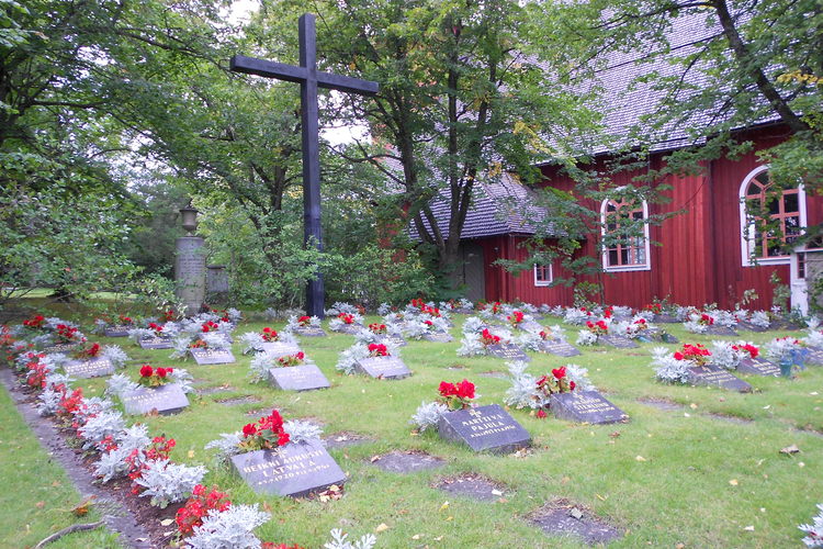 område med liggande gravstenar, blommor vid varje sten
